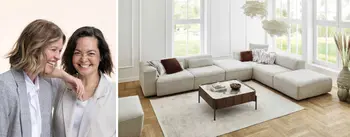 Zwei lachende Frauen in moderner Einrichtung neben einem grauen Cord-Sofa mit Longchair. Kombination aus Wohlfühlatmosphäre, modernen Möbeln und urbanem Lifestyle.